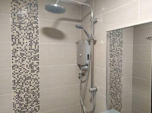 a shower with a glass door in a bathroom at The Square Hotel in Skudai