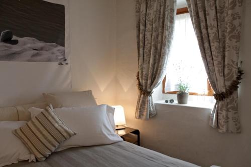 a bedroom with a bed and a window at Maison Bondaz & SPA privé in Aosta