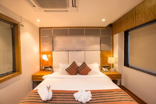ボーパールにあるHotel Shubh Innのベッドルーム1室(ベッド1台、テーブル2台、窓付)