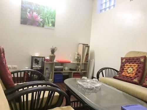 ein Wohnzimmer mit einem Sofa, einem Tisch und Stühlen in der Unterkunft LA house in Hanoi