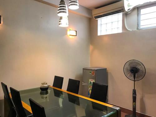 einen Konferenzraum mit einem Tisch, Stühlen und einem Ventilator in der Unterkunft LA house in Hanoi