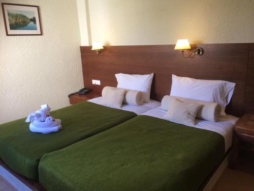 a bedroom with a large bed with a teddy bear on it at Porto Sisi Hotel Apartments in Sissi