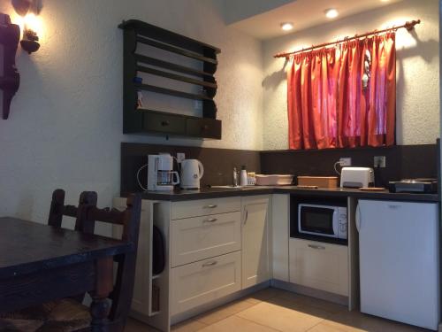 a kitchen with a counter with a microwave and a table at Porto Sisi Hotel Apartments in Sissi