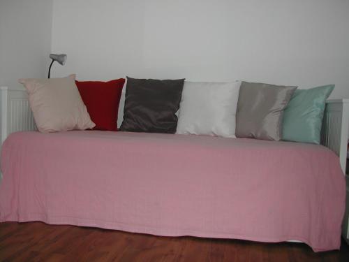 a couch with a bunch of pillows on it at Haus Polly in Strasshof an der Nordbahn