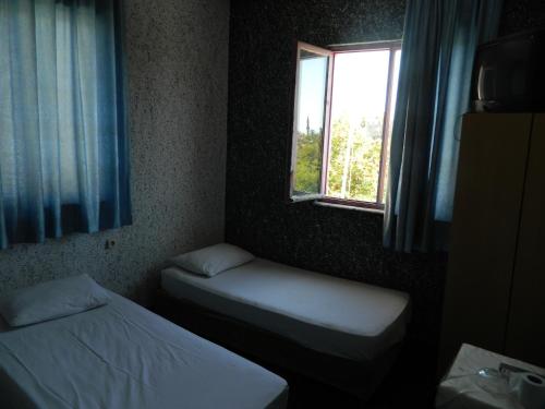 a small room with two beds and a window at Sunrise Hotel in Antalya