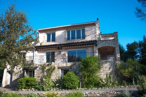 a stone house with a balcony on a hill at La Garriniere in Saint-Raphaël