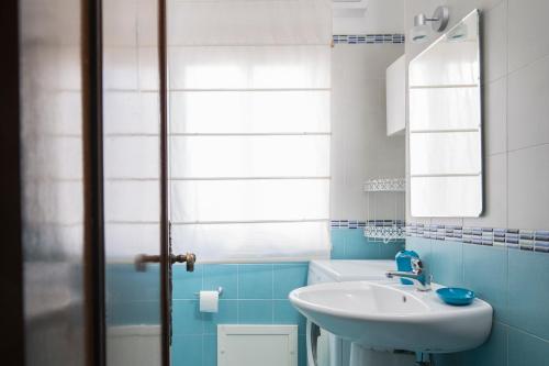 チェファルにあるFabiene Familyholidaysの青と白のバスルーム(シンク、鏡付)