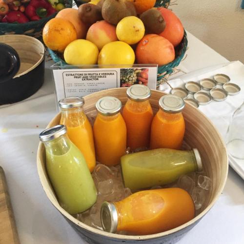 a bowl of fruits and bottles of juice on a table at Villa Kinzica in Sale Marasino