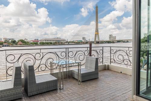 a balcony with chairs and a table and a view of the eiffel tower at V Varee Bangkok in Bangkok