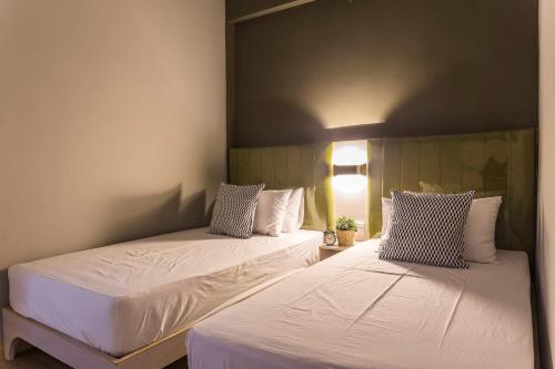 two beds sitting next to each other in a bedroom at V Varee Bangkok in Bangkok