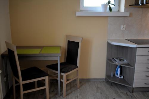 małą kuchnię z biurkiem, stołem i krzesłami w obiekcie DRAGON Apartments (Helena) w Krakowie