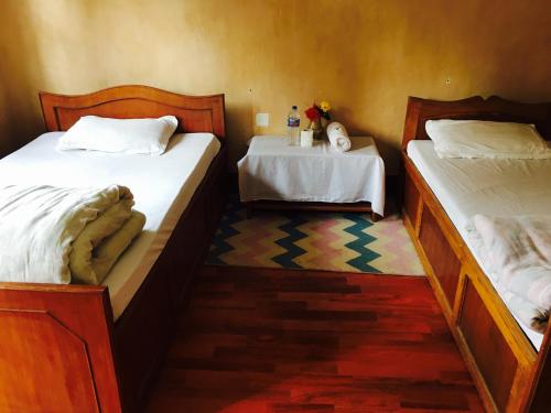 two twin beds in a room with at Shrestha Hotel & Restaurant in Bandipur