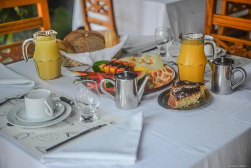 ein Tisch mit einem Teller Essen und Orangensaft in der Unterkunft Barracuda Eco Resort Búzios in Búzios