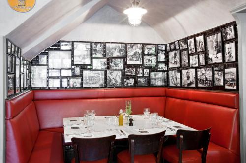 a dining room with a white table and red booths at Auberge de Banne in Banne