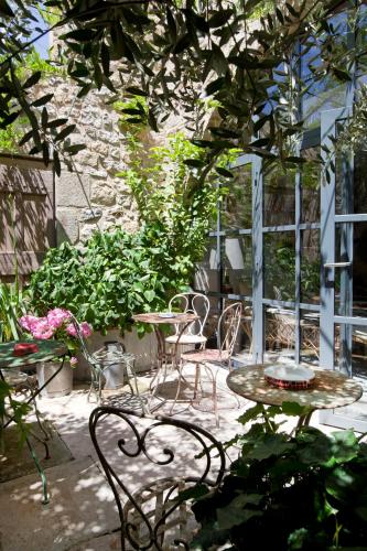 a patio with tables and chairs and plants at Auberge de Banne in Banne