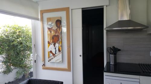 a door to a kitchen with a painting on the wall at Playa Del Ingles in Playa del Ingles