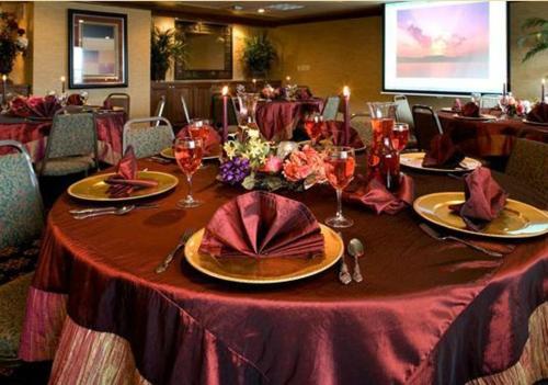a table with a red table cloth and wine glasses at Grand Gateway Hotel in Rapid City