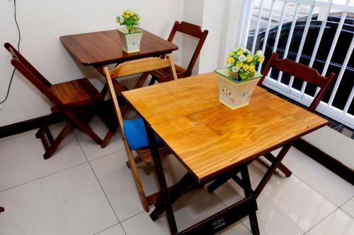 einen Holztisch mit zwei Stühlen und Blumen darauf in der Unterkunft Boulevard Bed & Breakfast in Rio de Janeiro