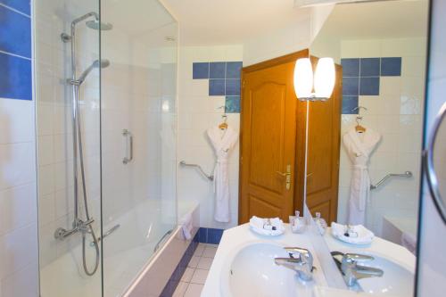 a bathroom with a sink and a shower and a tub at Hôtel Restaurant Du Port in Yvoire