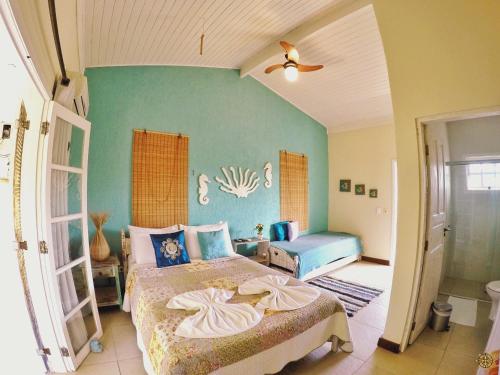 a bedroom with a large bed and a blue wall at Coco Bambu Cambury in Camburi