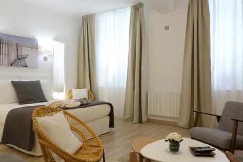 une chambre d'hôtel avec un lit, une chaise et une table dans l'établissement Arles Getaway - La Suite Arlésienne, à Arles