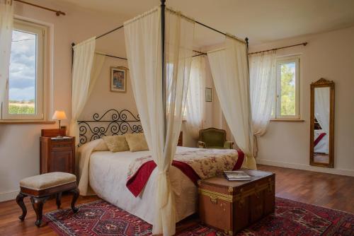 AguglianoにあるL'Antigo Granaroのベッドルーム1室(天蓋付きの大型ベッド1台付)