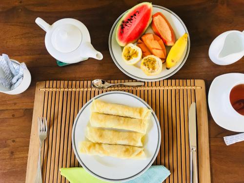 米瑞莎的住宿－美森迪三達海灘旅館，一张桌子,上面放着两盘面包和水果