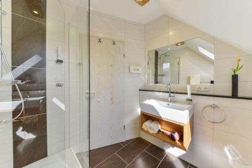 a bathroom with a sink and a shower at Landgasthof - Hotel Reindlschmiede in Bad Heilbrunn