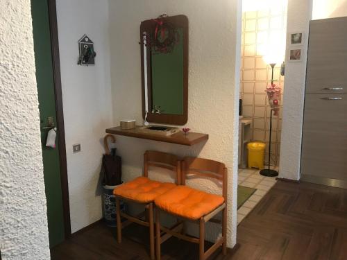 uma casa de banho com um toucador, um espelho e uma cadeira. em Appartamento Saint Gréé em Viola