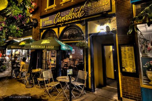a restaurant with tables and chairs in front of a building at Canalside Restaurant & Inn in Port Colborne
