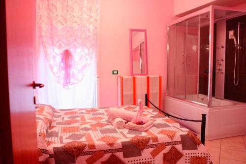 ジャルディーニ・ナクソスにあるCasa vacanze Giusyのピンクのベッドルーム(ベッド1台、シャワー付)