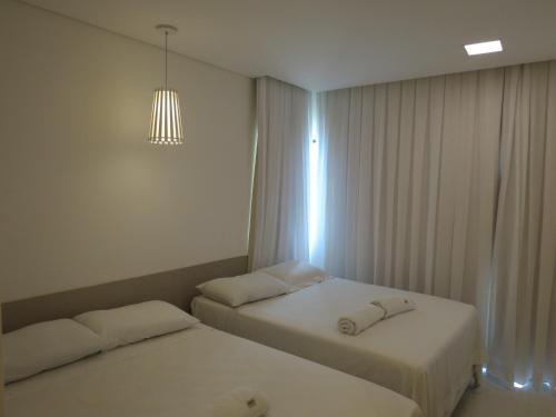 2 camas en una habitación de hotel con lámpara de araña en Flats Deco Design Beira Mar Prime en Recife