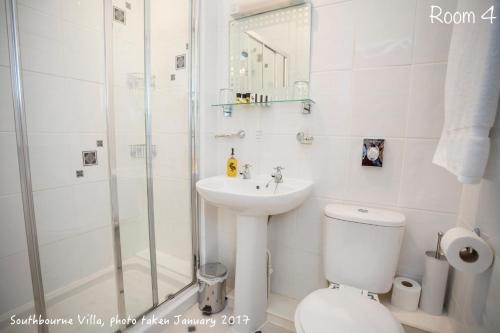 a bathroom with a shower and a toilet and a sink at The Southbourne Villa in Torquay