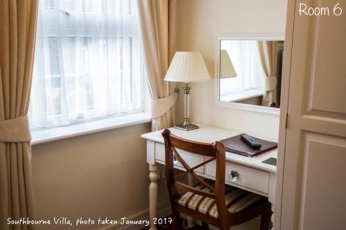 a room with a desk with a mirror and a chair at The Southbourne Villa in Torquay
