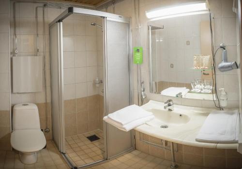 a bathroom with a shower and a sink and a toilet at Hotel Kittilä in Kittilä