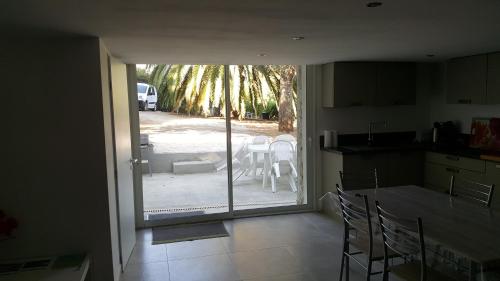 d'une cuisine avec une porte coulissante en verre s'ouvrant sur une terrasse. dans l'établissement Rez de Villa, à Loreto-di-Tallano