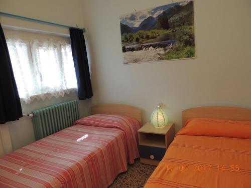 a bedroom with two beds and a picture on the wall at Appartamento San Ambrogio in Cannobio