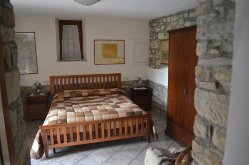 - une chambre avec un lit et un mur en pierre dans l'établissement Agriturismo Flora, à Chiusi della Verna