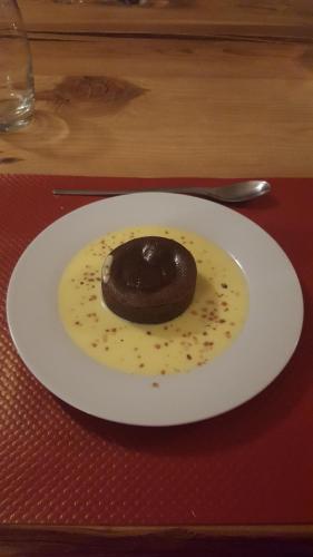 a chocolate donut on a white plate on a table at Le Bacchu Ber in Briançon