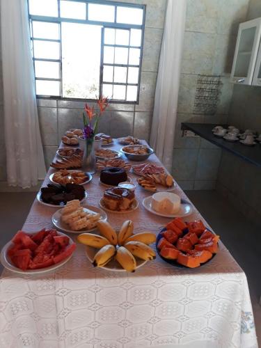 Chalés Colina de Casa Branca في برومادينهو: طاولة عليها العديد من أطباق الطعام