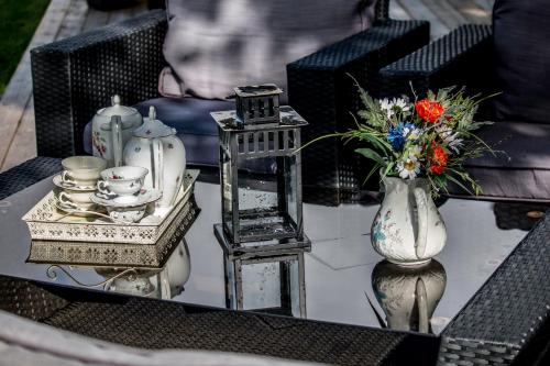 a coffee table with a vase of flowers and a vase at Stall Hällarp in Falkenberg