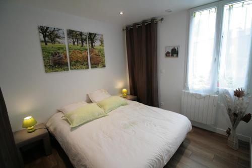 um quarto com uma cama branca e uma janela em Gîte Pays D'Auge Lisieux Centre em Lisieux