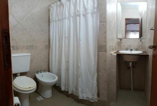 y baño con aseo, lavabo y ducha. en Las Rosas en Costa del Este