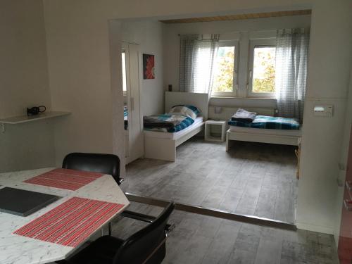 イダー・オーバーシュタインにあるKRIO Nicola Rothfuchs Ferienwohnung 1のベッド2台、テーブル、椅子が備わる客室です。