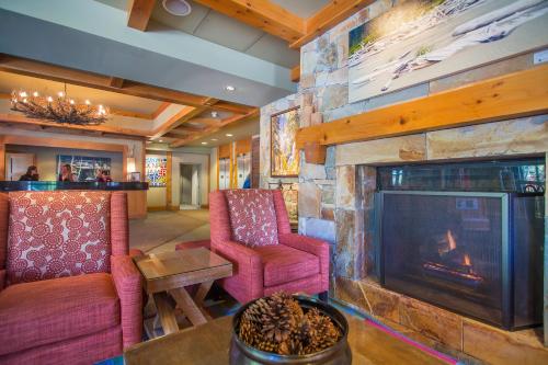 a living room with a fireplace and a stone wall at Sundial Hotel in Whistler