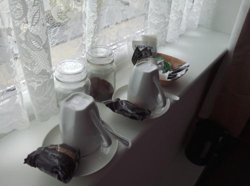 uma mesa branca com duas chávenas e frascos em Maggie's em Inveraray