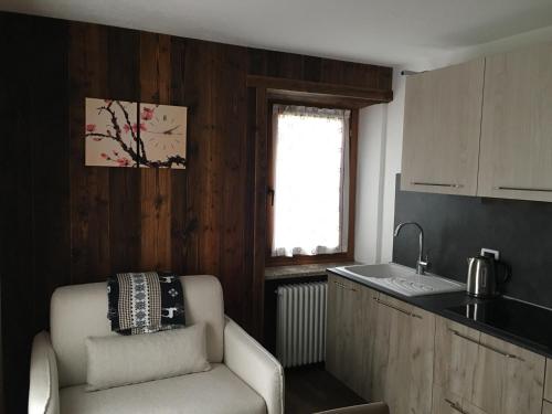 a kitchen with a chair and a sink and a window at La Maison de Pagan Alloggio ad uso turistico VDA CHARVENSOD n 0021 in Aosta