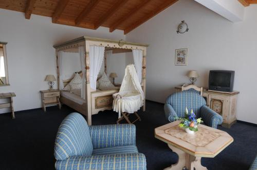1 Schlafzimmer mit einem Bett, 2 Stühlen und einem Tisch in der Unterkunft Landhaus Waldfrieden in Tengen