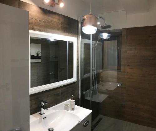 La salle de bains est pourvue d'un lavabo, d'un miroir et d'une baignoire. dans l'établissement Veneția Apartament - Timisoara, à Timişoara