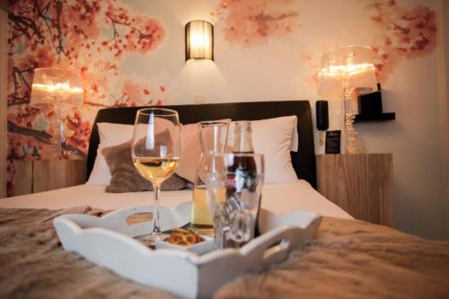 Villa Valentino في هاسيلت: طاولة مع كأسين من النبيذ وصينية من الطعام